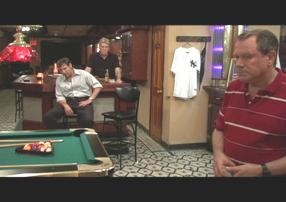 A group of people playing pool in a room.